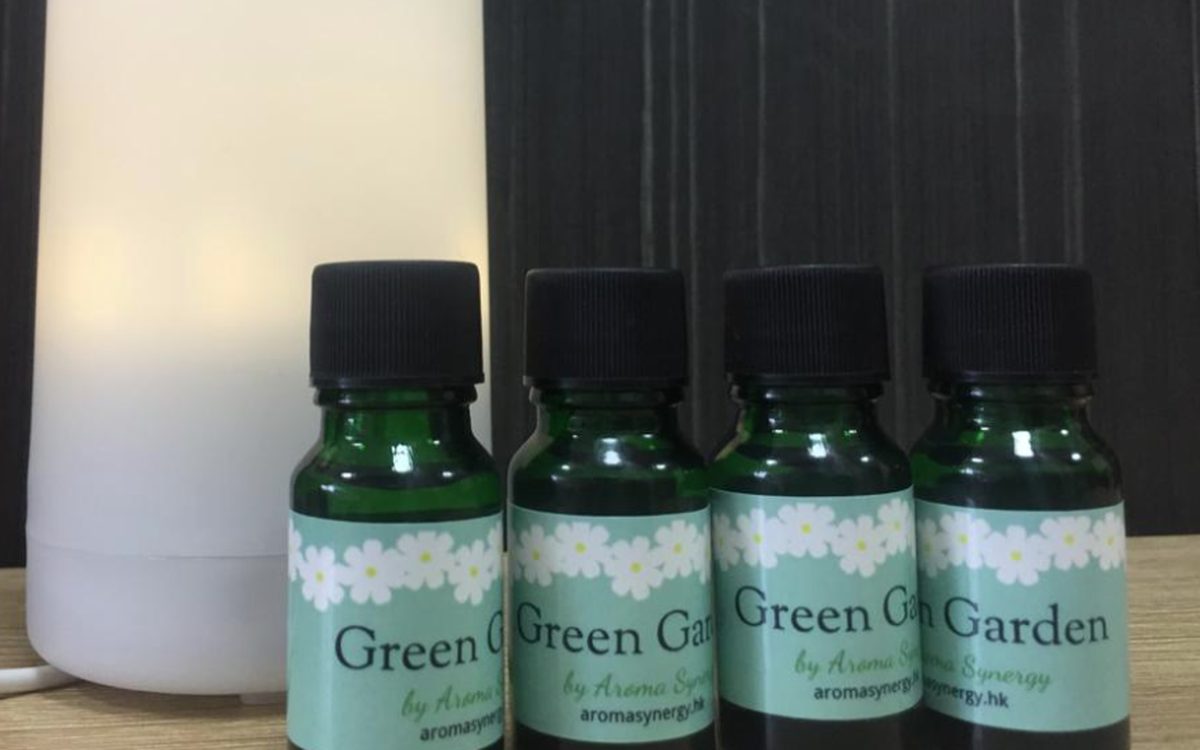 Green Garden essential oil bottles beside a lit ultrasonic aroma diffuser